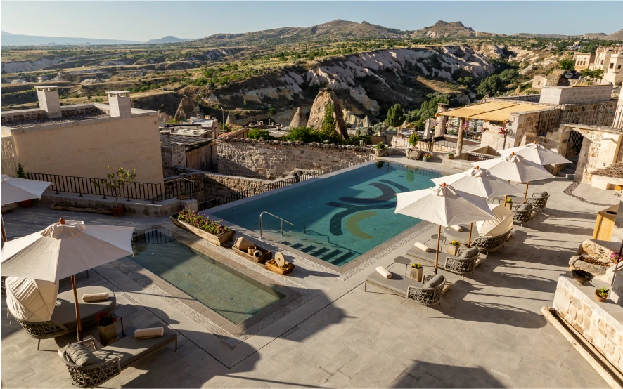 Umbrella-shaded pool with valley view at Argos in Cappadocia