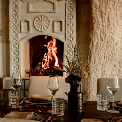 Stone lounge with fireplace and seating at Argos in Cappadocia
